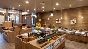 A modern breakfast bar with wooden counters, a variety of breakfast items, and a decorative vase of flowers. - Hotel Route-Inn Shunan-Tokuyama Higashi Inter- (Shunan)