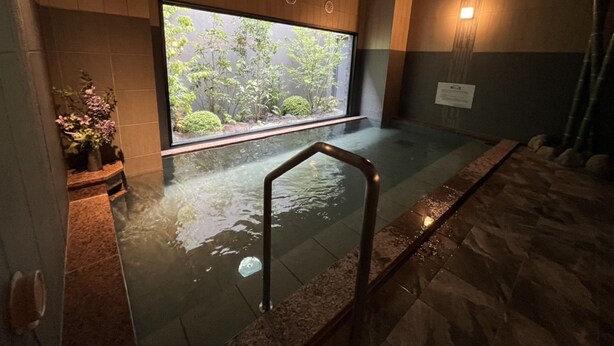 A spa area with a large window, a small pool, and a wooden wall. - Hotel Route-Inn Shunan-Tokuyama Higashi Inter- (Shunan)
