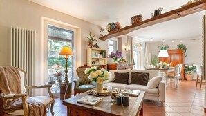 A cozy living room with a wooden coffee table, a sofa, and a bookshelf. - Villa Ester, a Stylish Farmhouse with Pool on the Hills by Lucca (Capannori)