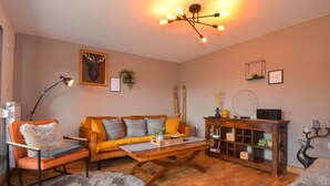 A cozy living room with a sofa, armchair, coffee table, and a fireplace. - Vacation home Selma by Interhome (Suhl)