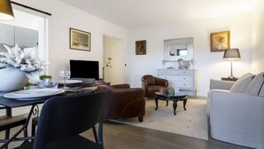 A modern living room with a dining area, a sofa, a coffee table, and a TV. - Jean Mermoz by Interhome (Deauville-Trouville)