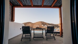 Un patio exterior con una mesa y sillas, vista de una montaña y una piscina al fondo.