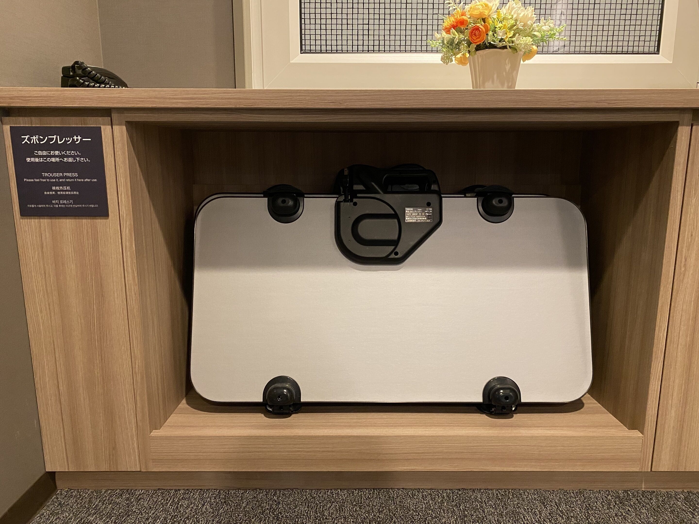 A suitcase in a wooden display case with a sign in Japanese.