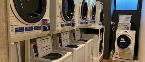 A row of front-loading washing machines in a commercial setting.