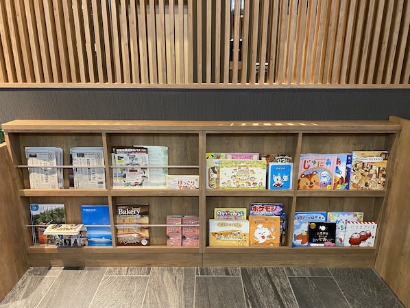 A wooden bookshelf with various books and guides. - Hotel Route Inn Osaka Izumifuchu (Izumi)