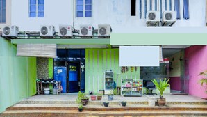 A storefront with a green awning, a blue door, and a white signboard. - Hotel O Emes Jaya HomestayNearSamsung Electronic Indonesia PT (Batam)