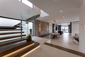 Ein modernes Interieur mit Treppe, Essbereich und Küche.