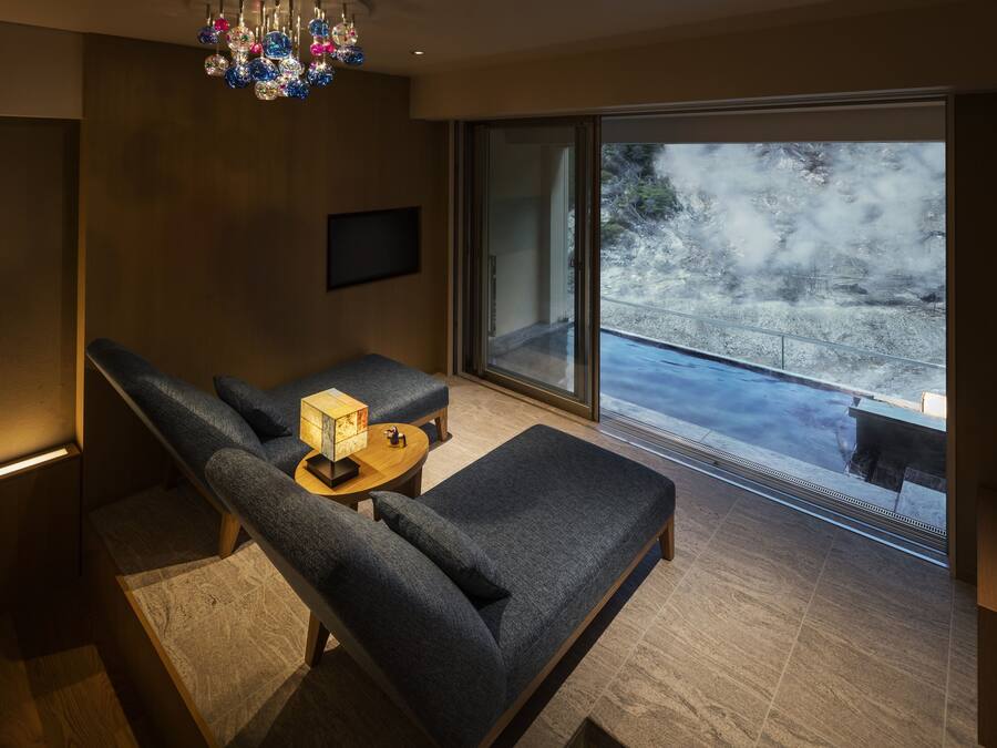 Un salon moderne avec un canapé, une petite table et un téléviseur.