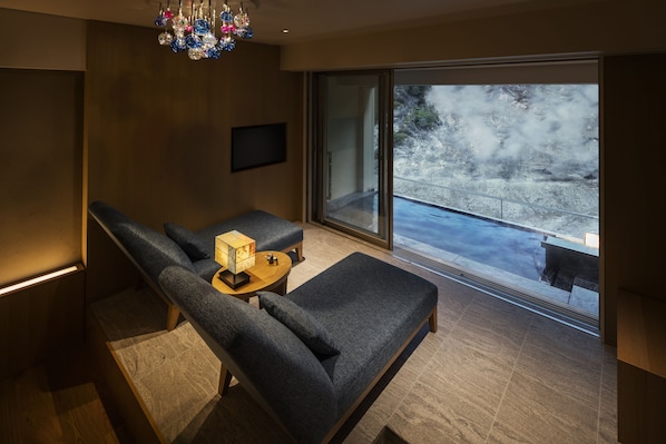 Uma sala de estar moderna com um sofá, uma mesinha e uma televisão.