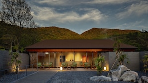 A modern building with a flat roof, large windows, and a seating area with chairs and tables. - Hoshino Resorts KAI Unzen (Unzen)