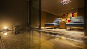 Un interior moderno con dos sillones azules, una mesa de centro de madera y un mueble de pared colorido.