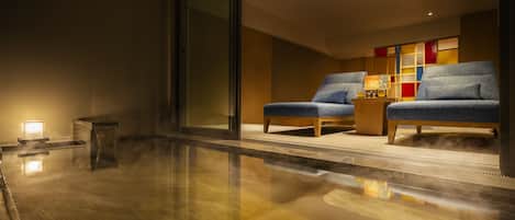 Un interior moderno con dos sillones azules, una mesa de centro de madera y un mueble de pared colorido.