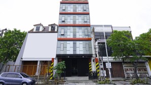 A multi-story building with a modern design, featuring a prominent entrance with a glass facade and a red accent. - Flagship 3688 Pot Art (Surabaya)