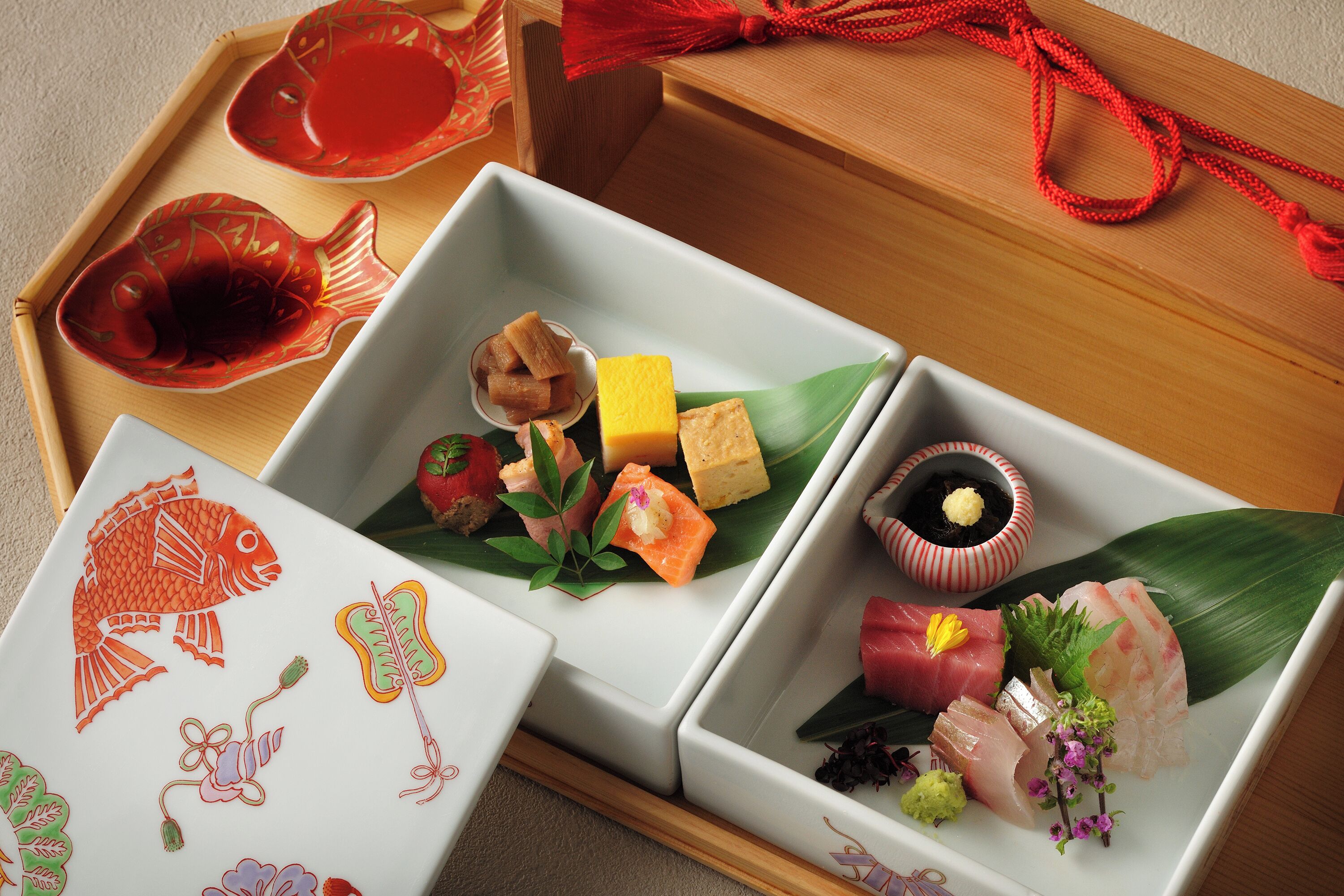 Una comida japonesa tradicional con varios platos sobre una bandeja de madera.