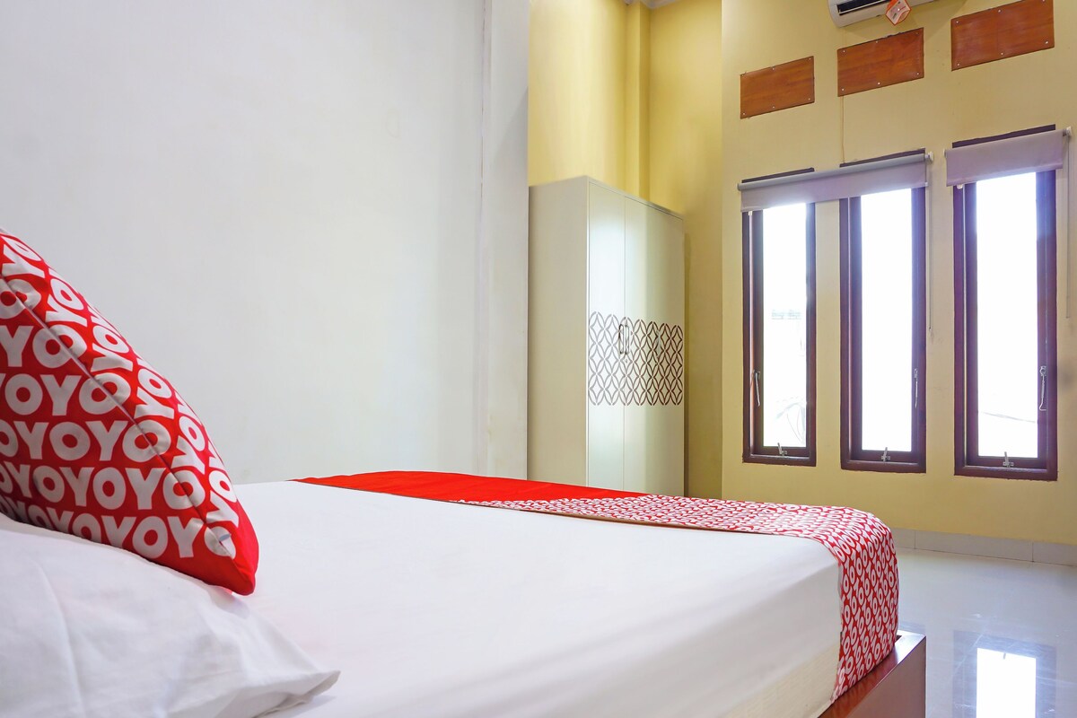 Una habitación de hotel con cama, armario y ventana con persianas.