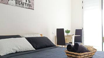 A bedroom with a bed, a desk, and a chair.