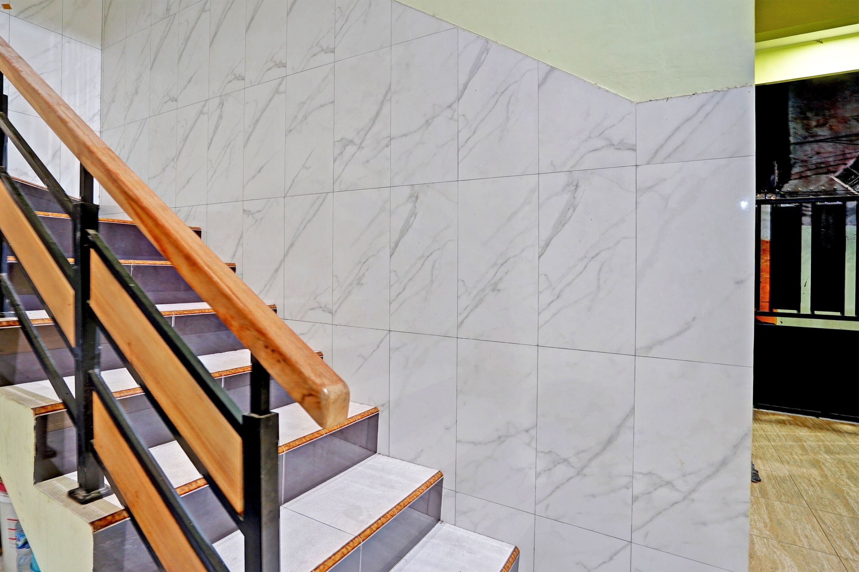 A staircase with wooden handrails and white marble steps.