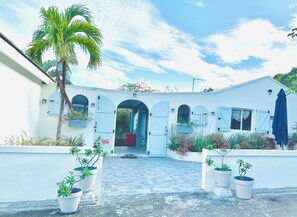 Un edificio blanco con arcos y un acceso con baldosas.