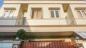 A two-story building with a flat roof, multiple windows with shutters, and a gated entrance. - OYO 91316 Hh Guest House Makassar (Makassar)