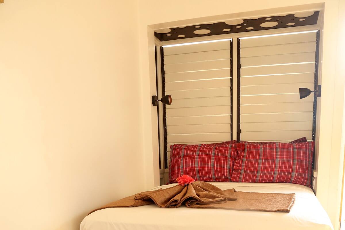 Une chambre à coucher avec un lit en bois, un tapis tissé et une armoire au design original.