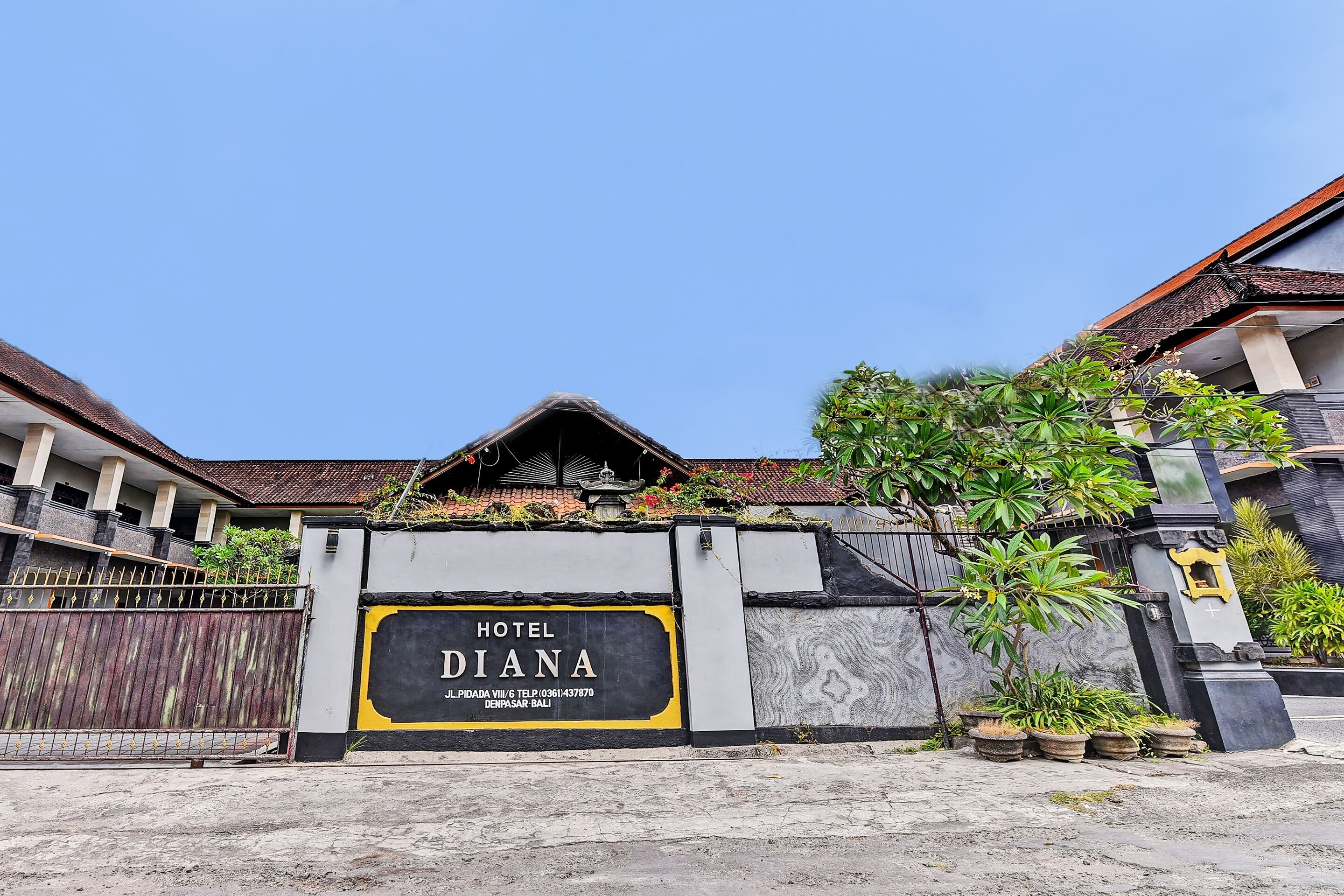 L’entrée d’un hôtel, avec une enseigne indiquant « HÔTEL DIANA » et un numéro de téléphone.