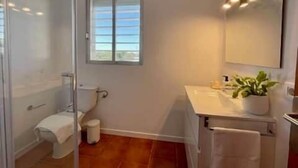 Un baño con ducha, inodoro y lavamanos.