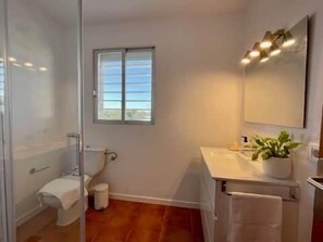 Une salle de bain avec une douche, des toilettes et un lavabo.