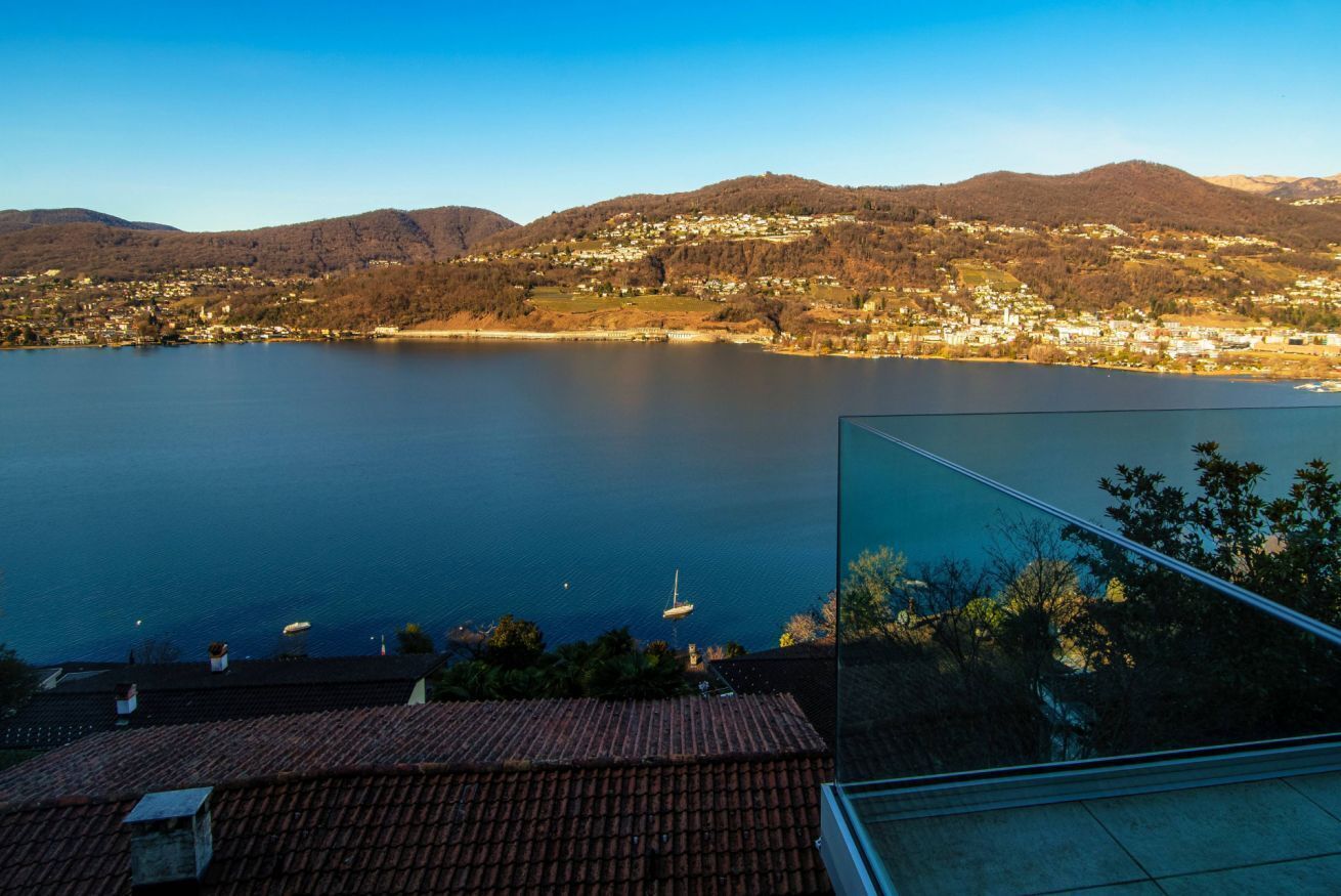 Un lago con un pueblo al fondo y un edificio moderno en primer plano.