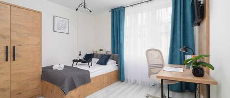 Escritorio, tabla de planchar con plancha, wifi y ropa de cama