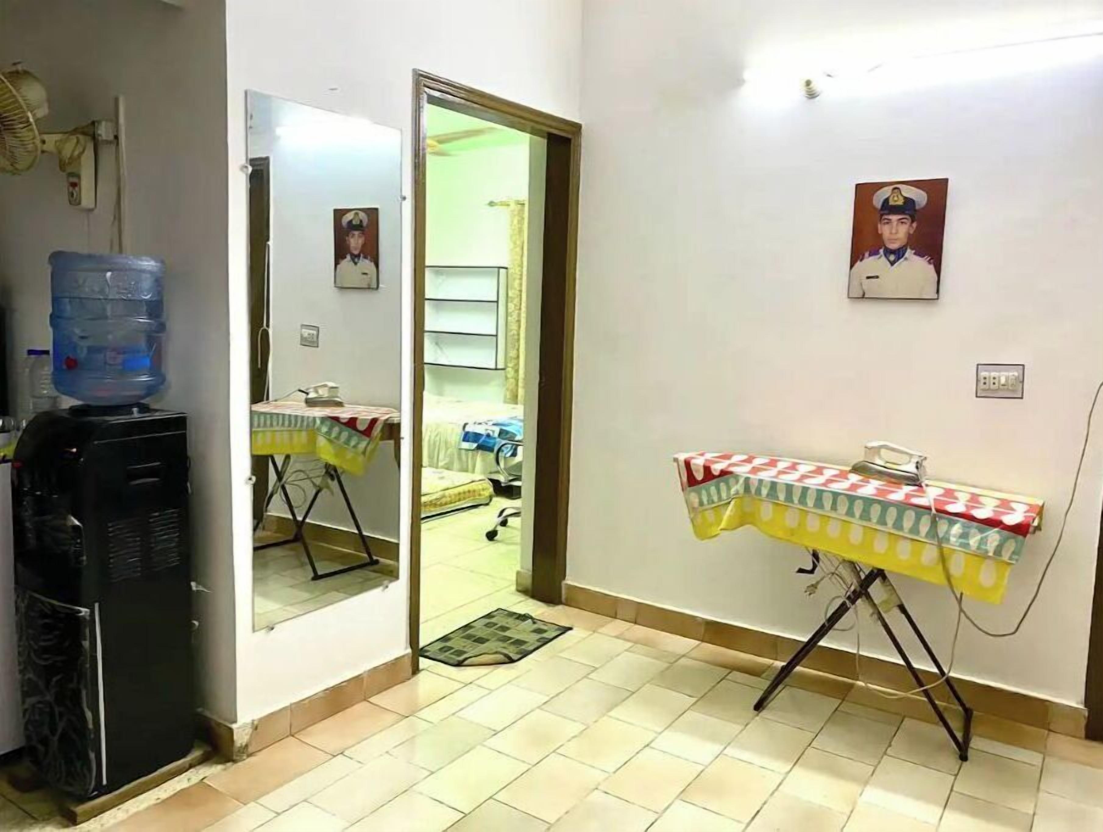 A hotel room with a water dispenser, a table with a tablecloth, and a bed.