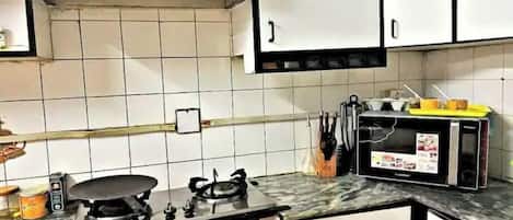 Functional kitchen with gas stove, microwave, and countertop space.