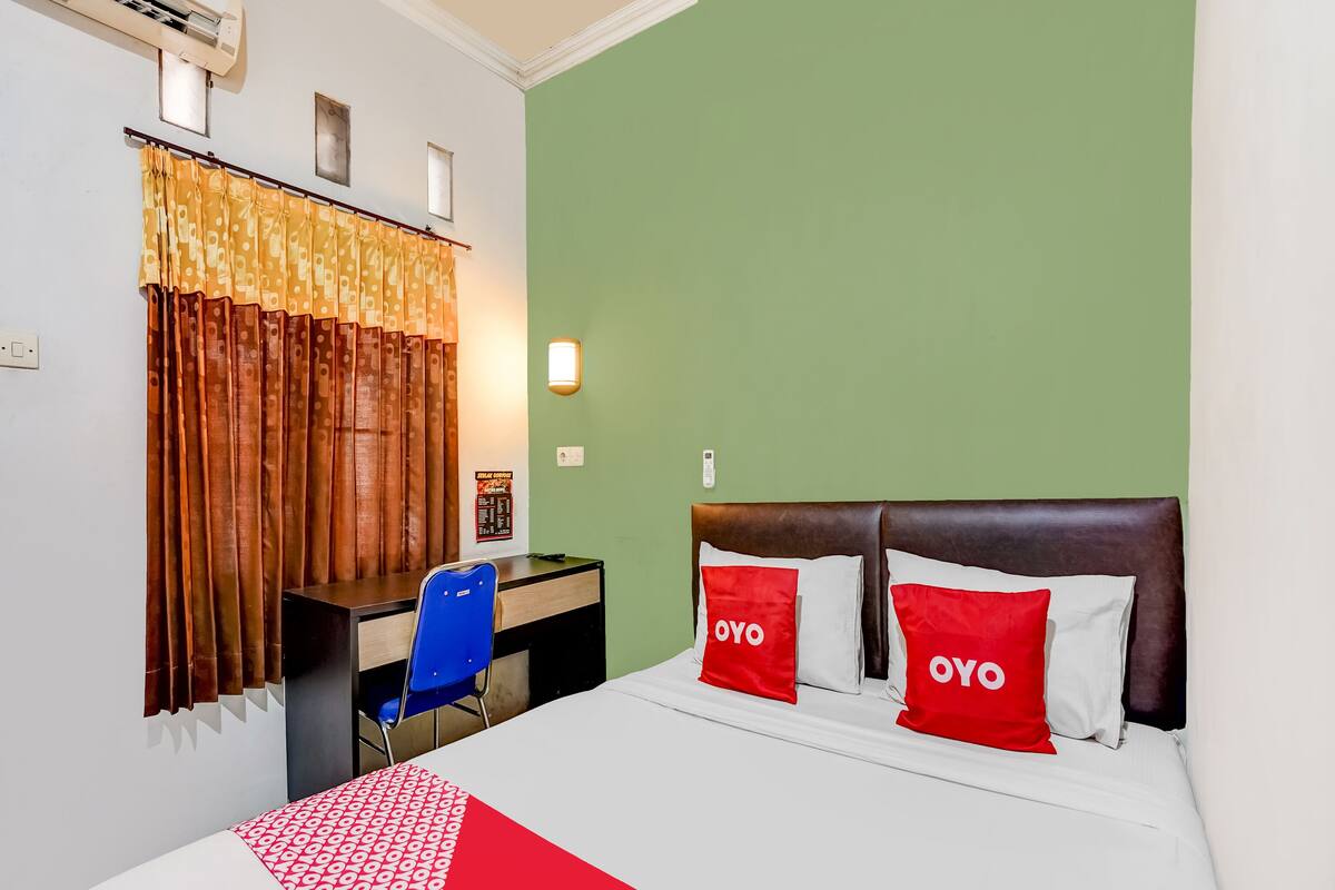 Une chambre d’hôtel avec un lit, un bureau et une chaise.