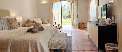 A bedroom with a bed, bedside table, and a view of the outdoors.