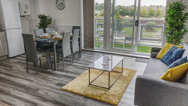 Ein modernes Wohnzimmer mit einer Couch, einem Couchtisch und einem Essbereich mit Stühlen und einem Tisch.