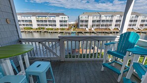 Eine Holzdielen-Terrasse mit Blick auf einen Yachthafen und Gebäude.
