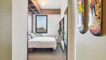 Ein Schlafzimmer mit Bett, Nachttisch und Fenster.