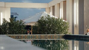 Un área de piscina moderna con una vista despejada de una montaña al fondo.