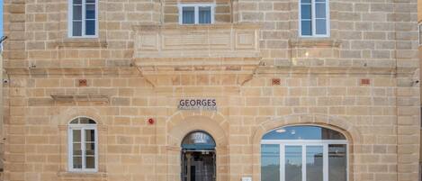 Un edificio de piedra con un letrero que dice 'GEORGES Boutique Linking'.