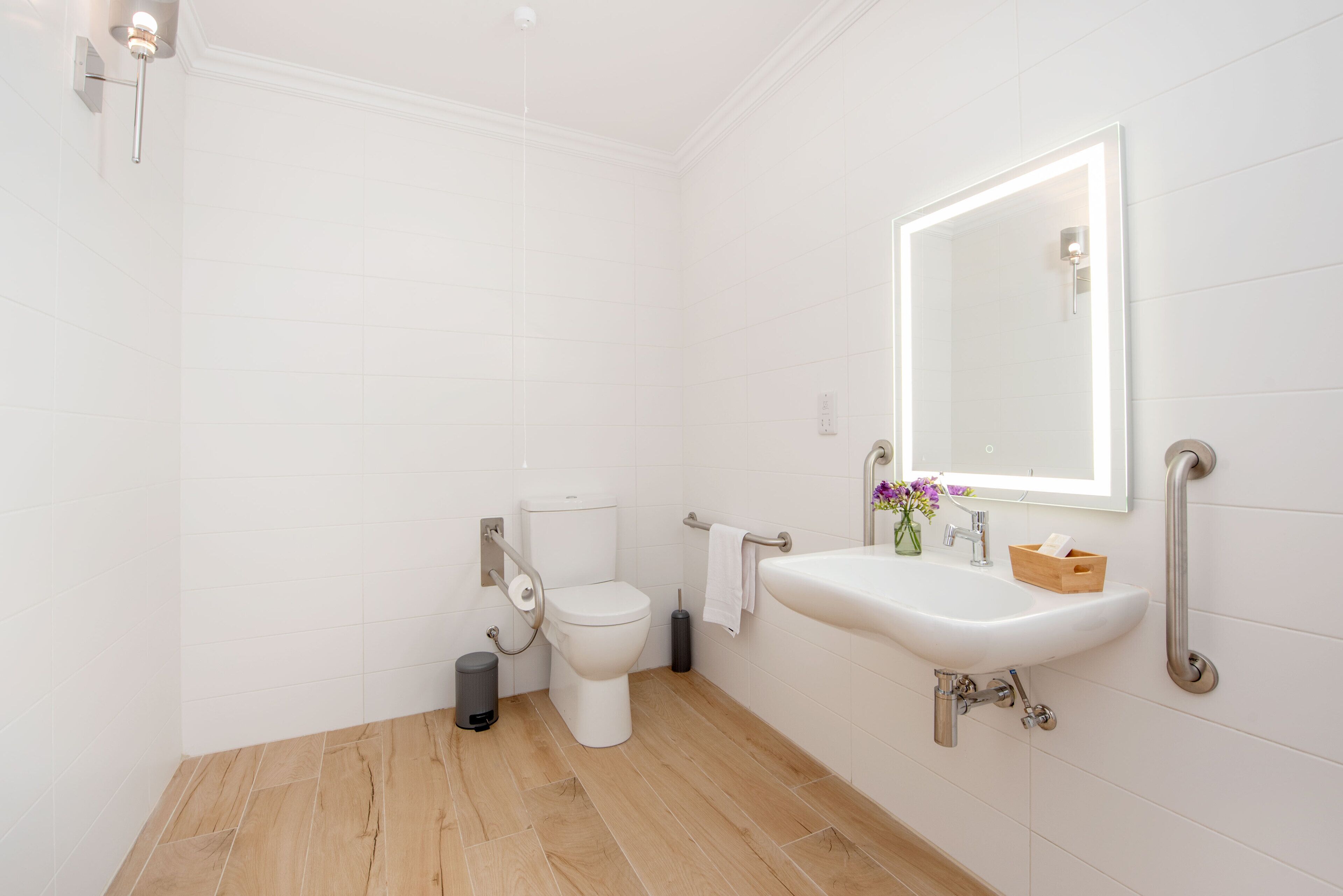 Ein modernes Badezimmer mit Toilette, Waschbecken und Spiegel.