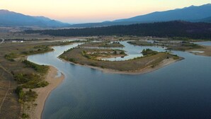 Vue aérienne d’un lac parsemé de nombreuses îles, entouré d’une forêt.