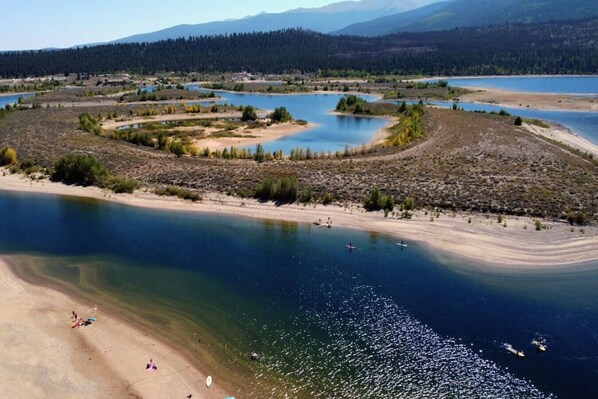 A river with a sandy beach and boats.