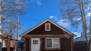A small wooden cabin with a porch, two chairs, and a door. - Stay Twin Lakes Cabin 3 (Twin Lakes)