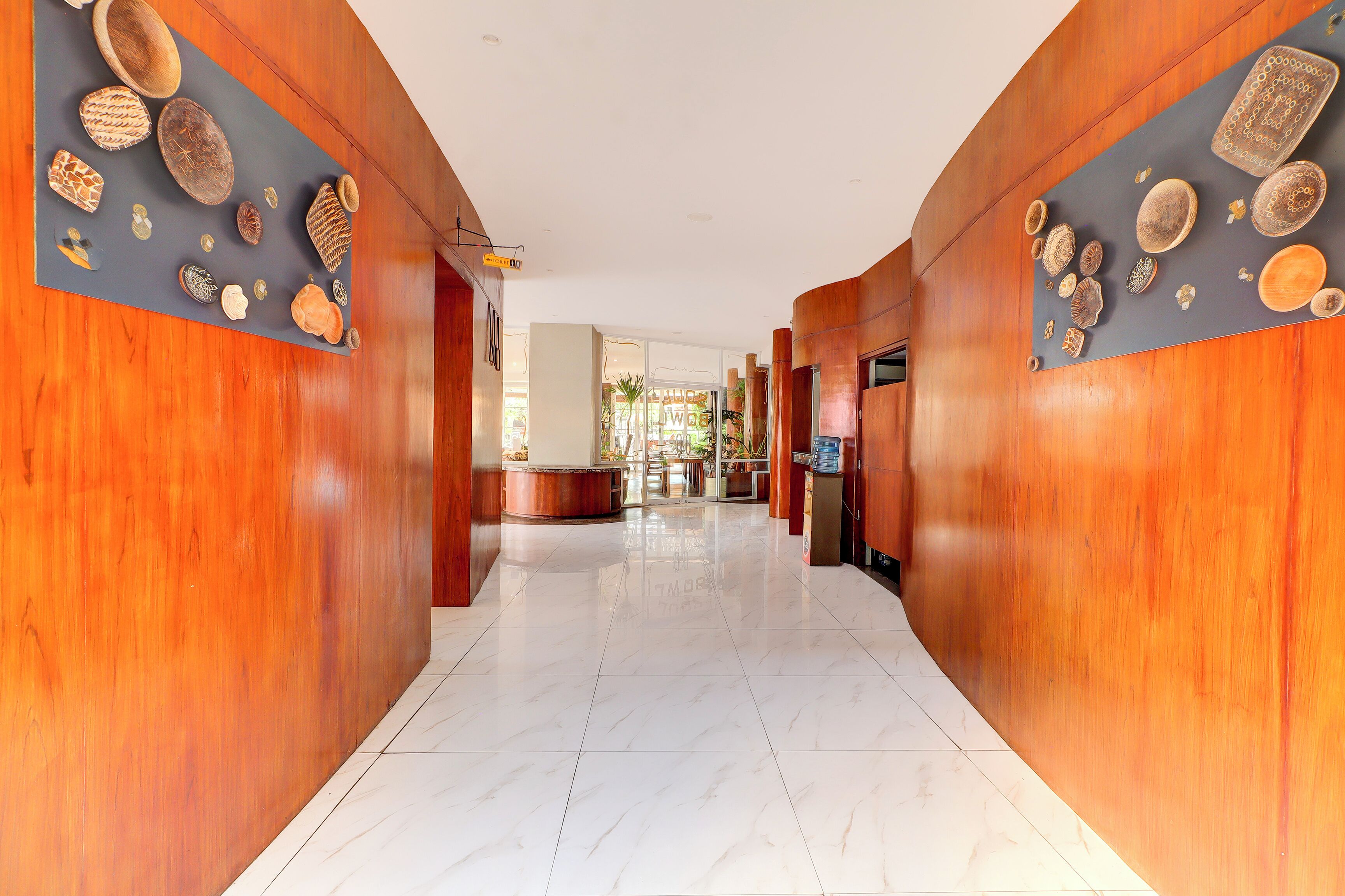 A hotel lobby with wooden paneling and a polished marble floor.