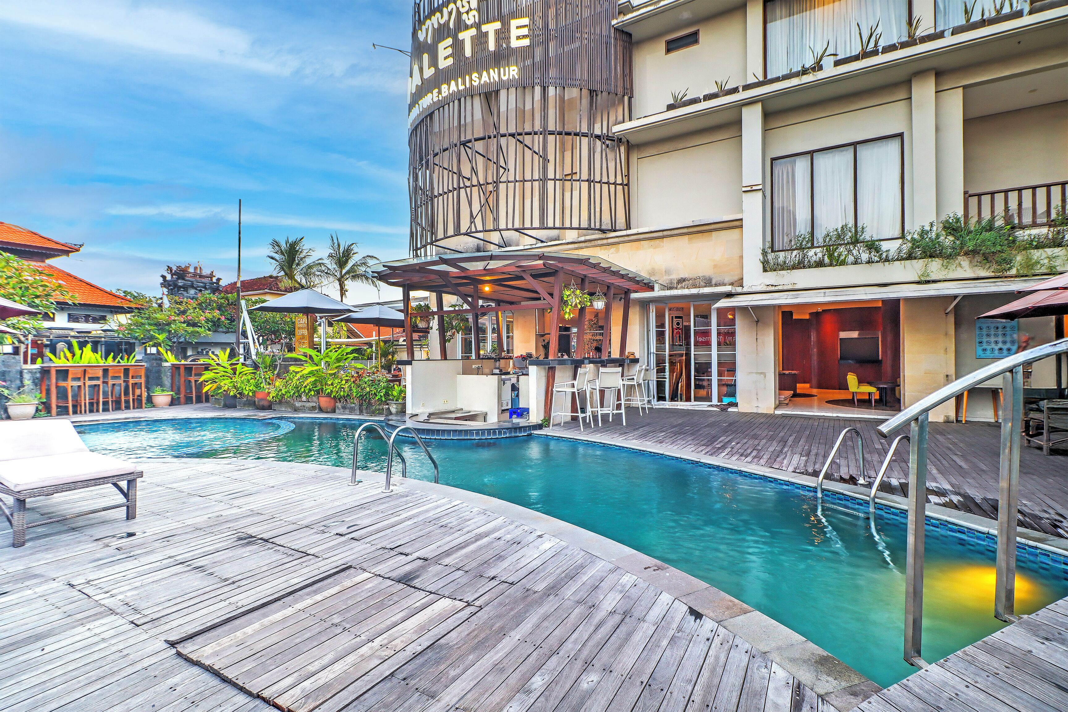 A hotel with a pool area, outdoor seating, and a bar.