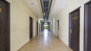 A long, narrow hallway with doors numbered 2103 and 2104 on the right. - OYO 91035 De Ritz Residence (Surabaya)