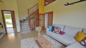 Ein Wohnzimmer mit einer Couch, einem Holztisch und einer Treppe.