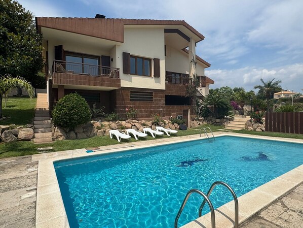 A two-story house with a swimming pool, a stone staircase, and a fenced garden area. - Villa 'Carme' with Sea View, Wi-Fi and Air Conditioning (Calonge)
