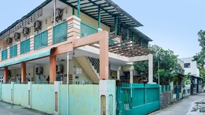 Un immeuble à plusieurs étages doté d’un balcon couvert, de climatiseurs et d’un escalier.