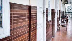 Un couloir aux murs recouverts de lambris en bois et une porte blanche.