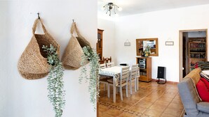 A dining area with a white table, chairs, and a bookshelf.